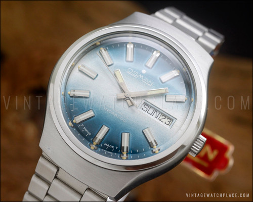 NOS Osman 2378W3 vintage automatic watch in stainless steel, with green textured dial, day-date calendar, original bracelet and hang tag.