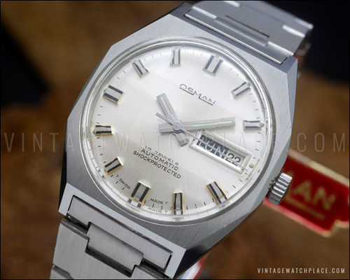NOS Osman 982 vintage automatic watch in stainless steel, with silver dial, day-date calendar, faceted Plexiglas crystal and original steel bracelet.