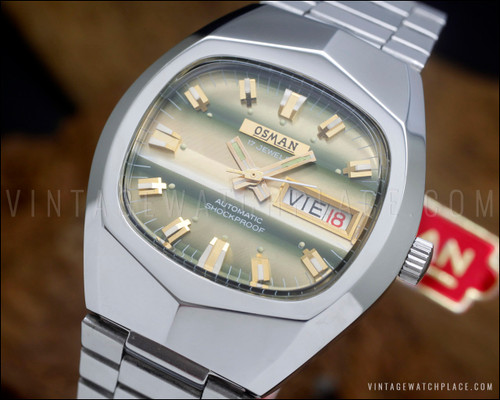 NOS Osman vintage automatic watch in stainless steel, with champagne-green striped dial, day-date calendar, faceted Plexiglas crystal and original steel bracelet.