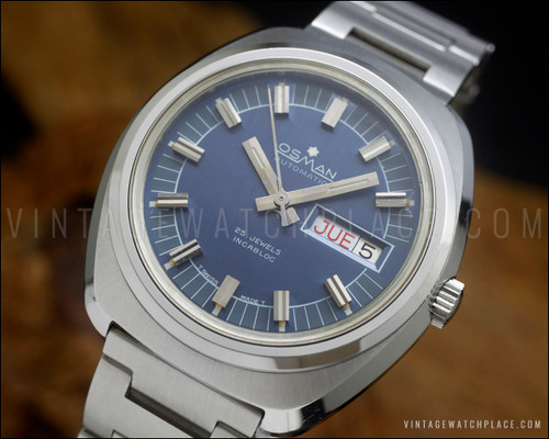 NOS Osman vintage automatic watch in stainless steel, with two-tone blue dial, Spanish day-date calendar, raised silver-tone indexes and original steel bracelet.