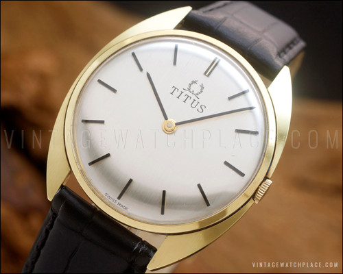 NOS Titus Swiss mechanical dress watch with brushed silver dial, elegant black baton hands and hour markers, 20-micron gold-plated case and black leather strap.