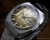 Angled view of the New Old Stock Sakay 61365A automatic, showing the gold patterned dial, day-date window and crown-side case profile.