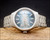 New Old Stock Osman 2378W3 automatic watch displayed on wood, with original hang tag, stainless steel bracelet and green textured dial.