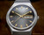 Front view of the Osman automatic watch, with brown dial, rare applied indexes, luminous hands and framed day-date display.