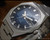 Close-up view of the Osman 982 automatic dial, showing the blue fumé finish, raised hour indexes, day-date calendar and faceted crystal.
