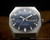 Front display of the Osman 982 NOS automatic watch, showing the full stainless steel bracelet, blue dial layout and day-date calendar.