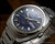 Close-up view of the Osman automatic dial, showing the two-tone blue finish, raised hour indexes, Spanish day-date calendar and vintage 1970s design.