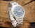 Angled view of the Osman NOS automatic watch on wood, highlighting the two-tone blue dial, raised silver-tone indexes, stainless steel case and original bracelet.