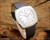 Angled view of the Osman NOS automatic watch on wood, highlighting the silver dial, raised silver-tone indexes, stainless steel case and genuine leather strap.
