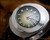 Close-up view of the Voga automatic dial, showing the green fumé finish, applied hour indexes, red central seconds hand and Spanish day-date calendar.