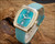 New Old Stock Tecnal automatic watch displayed on wood, with square 1970s case, turquoise dial, date window and matching new strap.