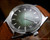Close-up view of the Tecnal automatic dial, highlighting the perfect green fumé finish, Incabloc marking, applied indexes and date window.