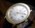 
Close-up of the Titus NOS automatic watch showing the silver dial texture, gold-tone hands, applied indexes and the distinctive brushed oval case.
