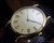 
Detailed angled view of the Zenith vintage quartz watch, highlighting its elegant dark hands, Roman numeral dial and sculpted gold-plated lugs.
