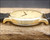 
Side profile of the NOS Zenith quartz watch, highlighting its polished gold-plated case, thin construction, curved lugs and crystal.
