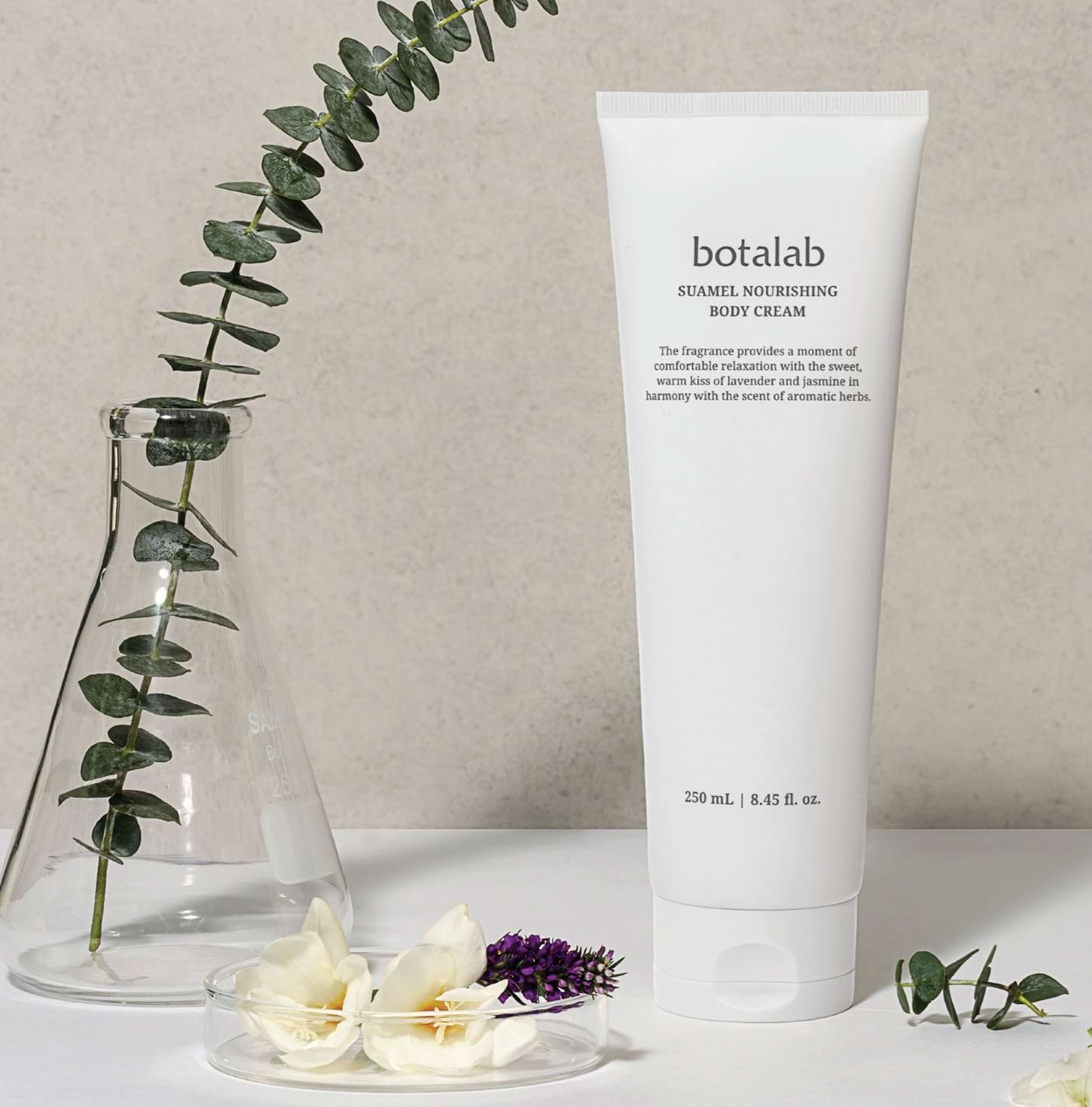 Suamel Nourishing Body Cream lifestyle with flowers and plants in the background