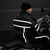Packaged black nylon waterproof motorcycle rain gear suit folded inside its compact storage carry bag