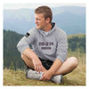 man sitting in a field wearing DD-214 Alumni Heather Grey Hoodie with American Flag on Sleeve