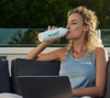 Woman drinking a Herbalife High Protein Iced Coffee Mocha (322g).