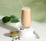 Herbalife Tri Blend Select Coffee Caramel Flavour Vegan Protein Shake Mix (600g) in a glass with coffee beans and caramel.