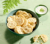 Bowl of Herbalife Nutrition Sour Cream and Onion flavour protein chips with a side of sour cream sauce. Bowl of Herbalife Nutrition Sour Cream and Onion flavour protein chips with a side of sour cream sauce.