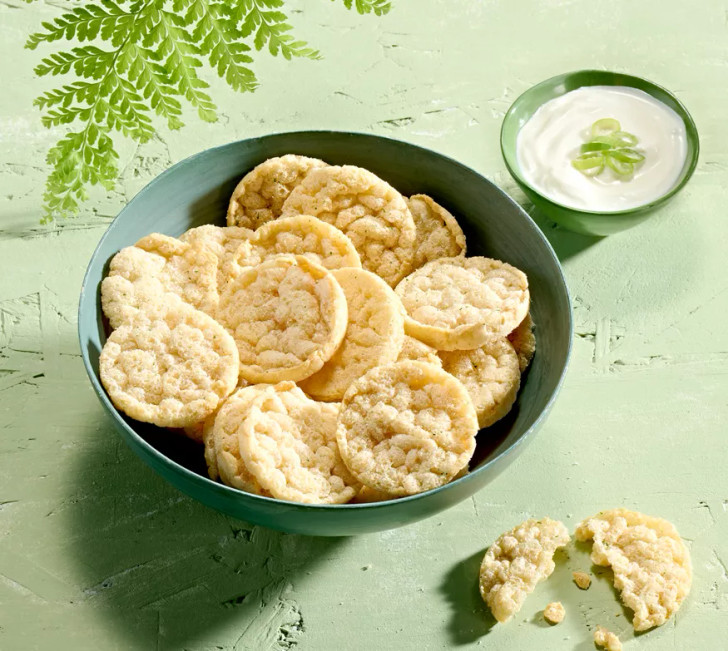 Bowl of Herbalife Nutrition Sour Cream and Onion flavour protein chips with a side of sour cream sauce.