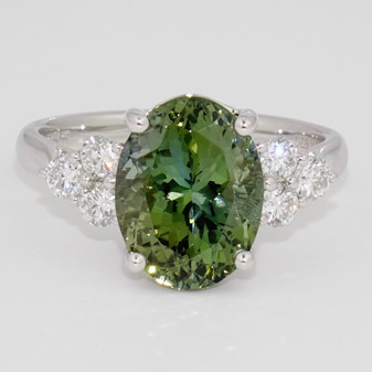 Platinum oval cut green tanzanite and six round brilliant cut diamond ring