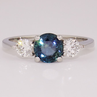 Platinum round cut teal sapphire and round brilliant cut diamond ring