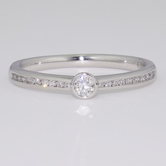 Platinum diamond solitaire ring with diamond-set shoulders