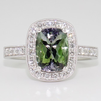 Platinum rectangular cushion cut mermaid tanzanite and round brilliant cut diamond halo ring with diamond-set shoulders and a milgrain edge