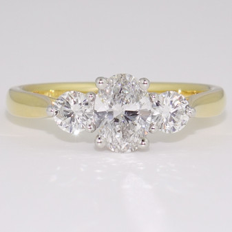 18ct gold and platinum ring with an oval cut diamond and two round brilliant cut diamonds