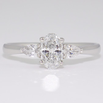 Platinum ring with a certificated oval cut E colour diamond between two pear cut diamonds