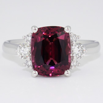 Platinum cushion cut malaya garnet and six graduated round brilliant cut diamond ring