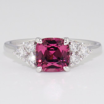 Platinum cushion cut malaya garnet and six round brilliant cut diamond ring