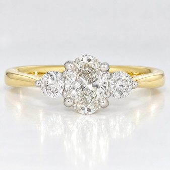 18ct gold and platinum ring with a GIA certificated oval cut diamond and two round brilliant cut diamonds
