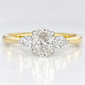 18ct gold and platinum ring with a GIA certificated oval cut diamond and two round brilliant cut diamonds