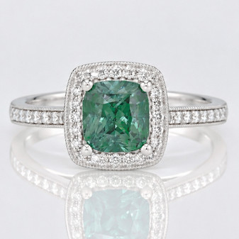 Platinum cushion cut Madagascan teal sapphire and round brilliant cut diamond halo ring with diamond-set shoulders