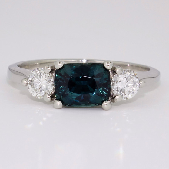Platinum cushion cut teal sapphire and round brilliant cut diamond ring