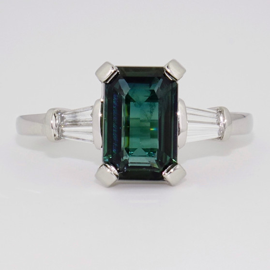 Platinum emerald cut teal sapphire and tapered baguette diamond ring