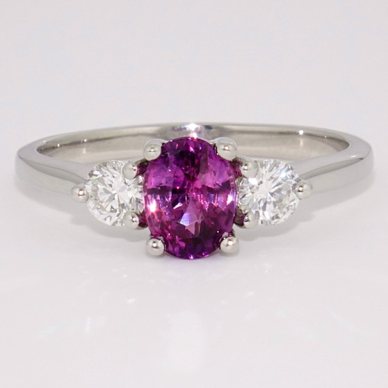 Platinum oval cut deep pink sapphire and round brilliant cut diamond ring