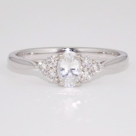 Platinum oval cut Madagascan white sapphire and round brilliant cut diamond ring