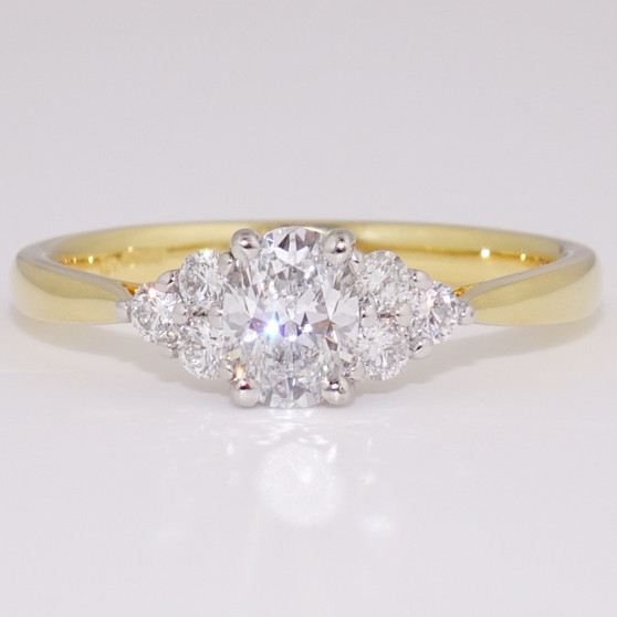 18ct gold and platinum ring with a certificated D colour oval cut diamond and six round brilliant cut diamonds