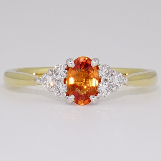 18ct gold and platinum oval cut orange sapphire and six round brilliant cut diamond ring