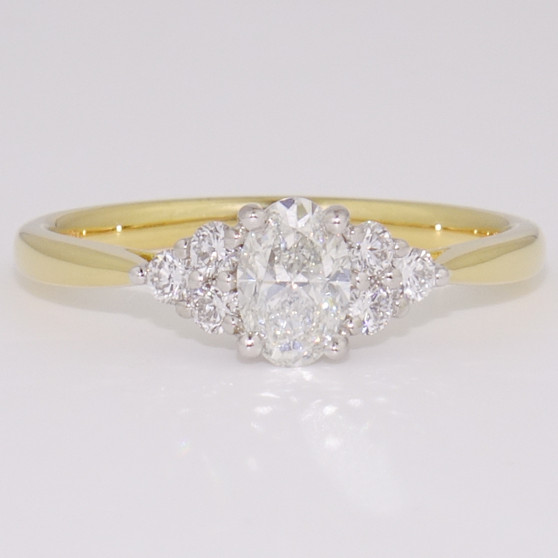 18ct gold and platinum ring with a certificated oval cut diamond and six round brilliant cut diamonds