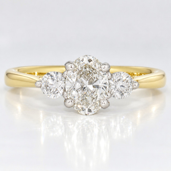 18ct gold and platinum ring with a GIA certificated oval cut diamond and two round brilliant cut diamonds