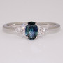 Platinum oval cut teal sapphire and round brilliant cut diamond ring
