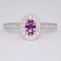 Platinum oval cut purple sapphire and round brilliant cut diamond cluster ring with diamond-set shoulders and milgrain edge