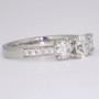 Platinum round brilliant cut diamond trilogy ring with diamond-set shoulders side