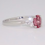 Platinum certificated unheated oval cut padparadscha sapphire and round brilliant cut diamond ring side