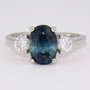 Platinum oval cut teal sapphire and round brilliant cut diamond ring